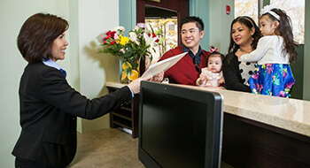 Dentist talking to family at front desk