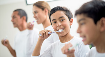 Family brushing their teeth together