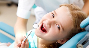 A little girl having her teeth checked at the dentist office