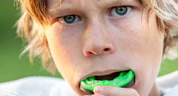 A young boy wearing an athletic mouthguard