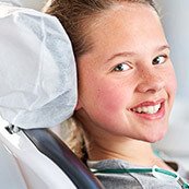 Young girl in dental chair smiling