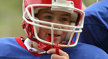 Young boy with football helmet and mouthguard