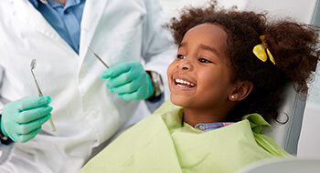 Happy young girl smiling in dental chair