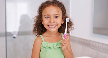 Smiling girl holding toothbrush