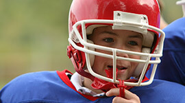 Young boy with football helmet and mouthguard