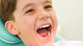 Happy young boy smiling in dental chair