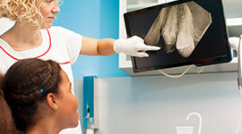 Patient and dental team member looking at x-rays