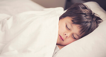 Young boy asleep in bed