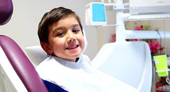 Young child in dental chair smiling