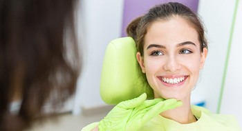A young female smiling at her dentist