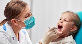 A little girl having her mouth checked at the dentist office