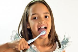 A young girl brushing her teeth.